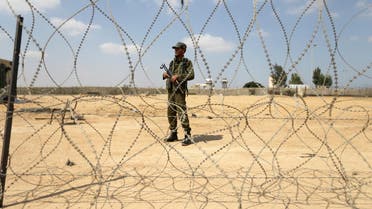 A member of the Palestinian security forces stands guard as men set up a barbed wire on the border with Egypt, in Rafah in the southern Gaza Strip, August 24, 2017. (Reuters)