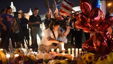 A woman lights a candle at a makeshift memorial near the Mandalay Hotel on the Las Vegas Strip, in Las Vegas, Nevada on October 3, 2017, after a gunman killed 58 people and wounded more than 500 others. (AFP)
