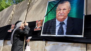 Iraqis hang posters of Iraq’s former president Jalal Talabanioutside the headquarters of the Patriotic Union of Kurdistan in Baghdad, on October 4, 2017, following his death the previous day in Germany. (AFP)