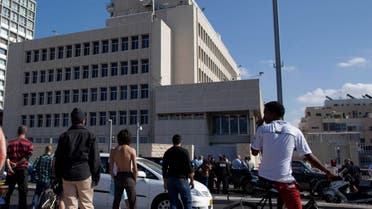 Israelis stand near the scene where a man attacked a security guard at the U.S. embassy, seen in background, in Tel Aviv, Israel, Tuesday, Nov. 20, 2012. ap