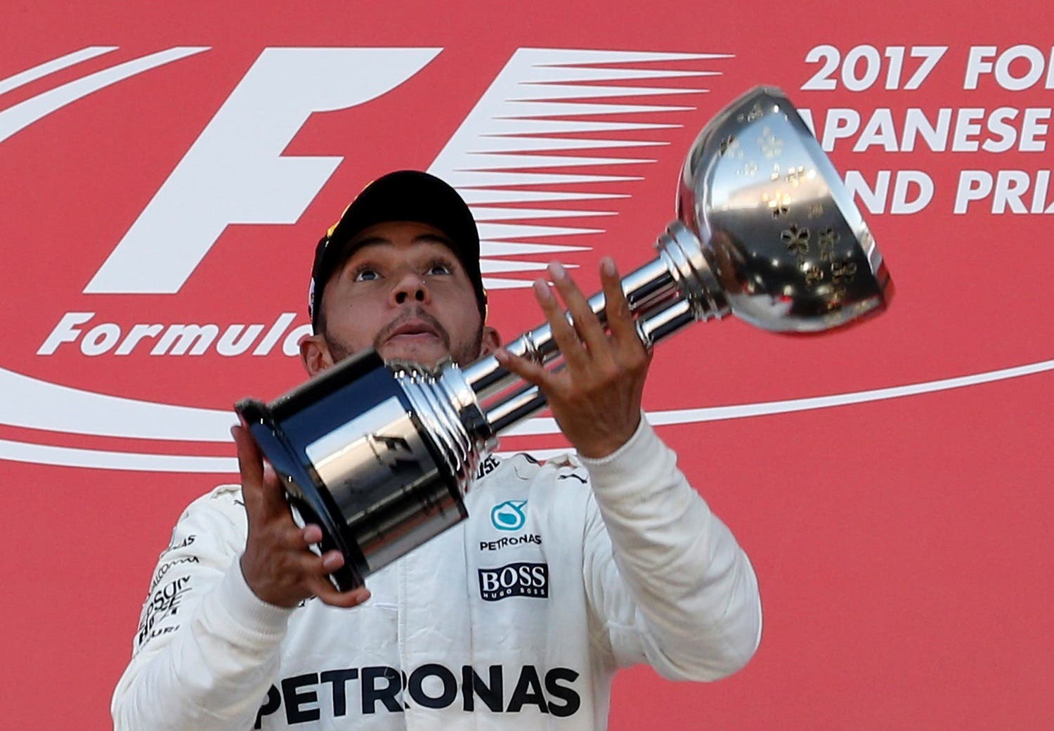 Mercedes’ Lewis Hamilton of Britain throws his trophy into the air as he celebrates winning the Japanese Grand Prix 2017 race. (Reuters)
