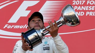 Mercedes’ Lewis Hamilton of Britain throws his trophy into the air as he celebrates winning the Japanese Grand Prix 2017 race. (Reuters)