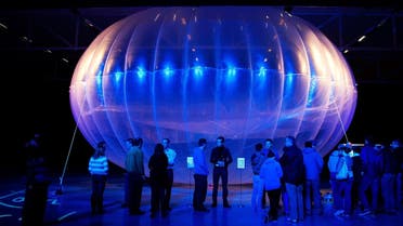 Visitors stand next to a high altitude WiFi internet hub, a Google Project Loon balloon, on display at the Airforce Museum in Christchurch. (AFP)