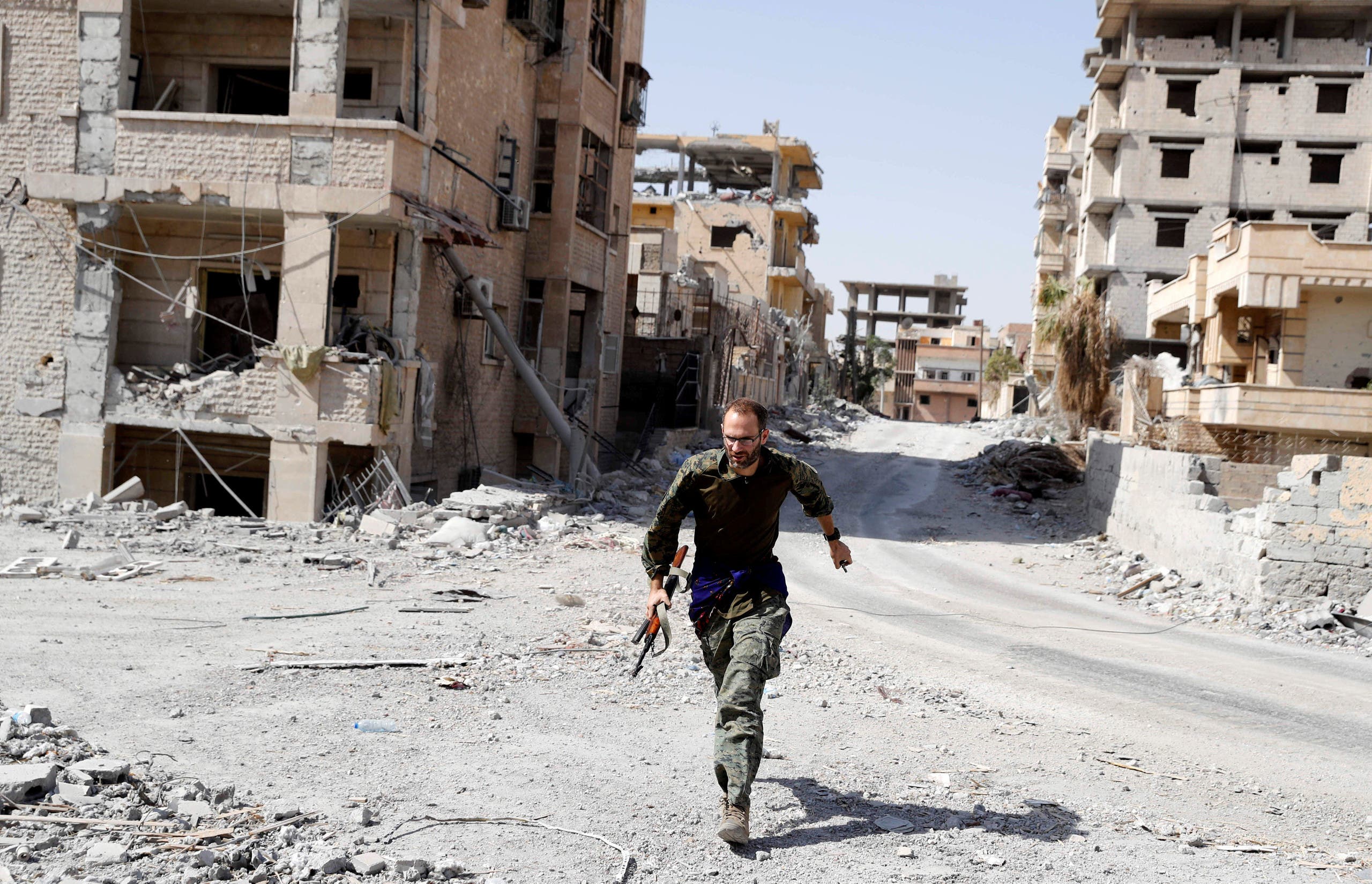 A British volunteer fighter of Syrian Democratic Forces runs for cover to avoid sniper fire of Islamic State militants, at the frontline in Raqqa, Syria October 7, 2017. REUTERS/