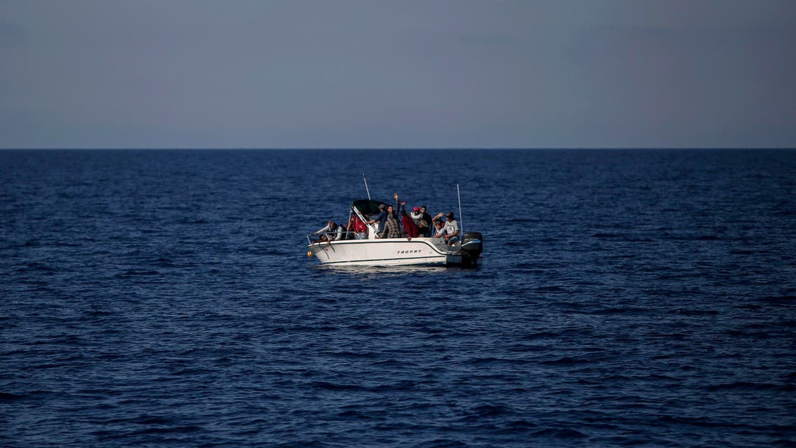 Migrants from Libya wave from a boat as they wait to be rescued by the Aquarius rescue ship run by NGO SOS Mediterranee and Medecins Sans Frontieres (MSF) in the Mediterranean Sea, 20 nautic miles from the Libyan coast, on August 2, 2017. Angelos Tzortzinis / AFP