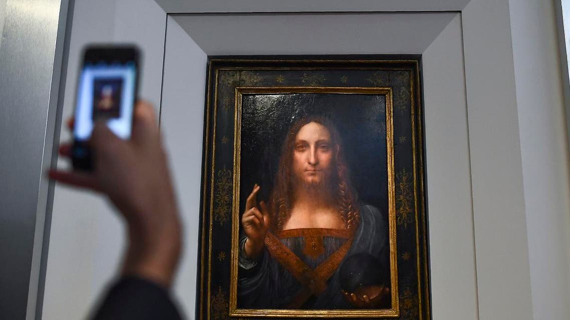 A journalist takes photos of Leonardo da Vinci's "Salvator Mundi" after it was unveiled at Christie's in New York on October 10, 2017. (AFP)