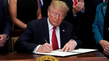 U.S. President Donald Trump signs an executive order to make it easier for Americans to buy bare-bones health insurance plans and circumvent Obamacare rules at the White House in Washington, U.S., October 12, 2017. reuters