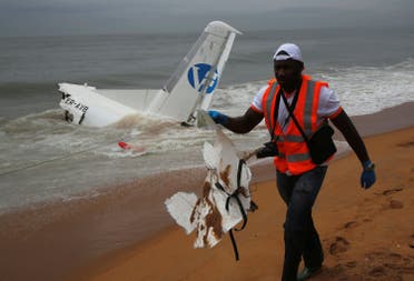 A rescuer carries a piece of a cargo plane after it crashed in the sea near the international airport in Ivory Coast’s main city, Abidjan. (Reuters)