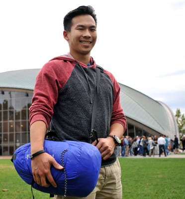 Vick Liu poses with his TravlerPack, a lightweight sleeping bag, outside the Kresge Auditorium at the Massachusetts Institute of Technology in Cambridge, Mass. (AP)