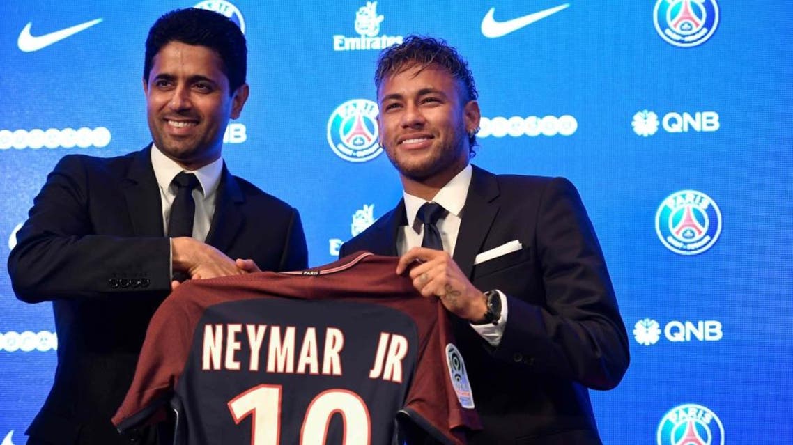 Neymar (R) poses with his jersey next to Paris Saint Germain's (PSG) president Nasser Al-Khelaifi during a press conference at the Parc des Princes stadium. (AFP)