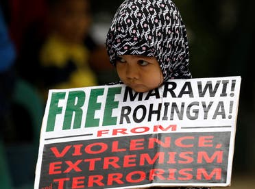 A Muslim young girl holds a placard after noon prayers for the Marawi siege and the plight of the Rohingya in Quezon City, Metro Manila. (AFP)