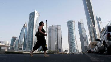 A woman crosses Al Wahda street hosting the Navigation Tower, headquarters of Qatargas (R), and Rasgas tower (2nd R) in Doha, April 8, 2013. (File photo: Reuters)