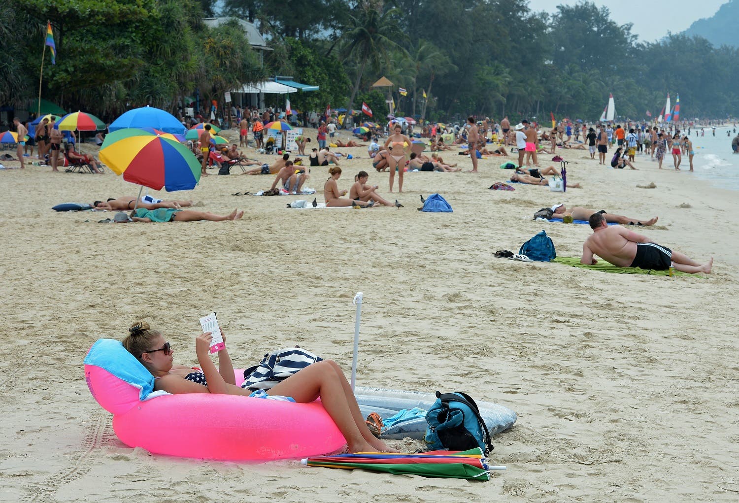 Foreign tourists relax at Patong beach in Phuket province on December 25, 2014. In the morning of December 26, 2004 a 9.3-magnitude earthquake off Indonesia's western coast generated a series of massive waves that killed more than 220,000 people across 14 countries as far apart as Indonesia, Sri Lanka and Somalia. AFP PHOTO/Pornchai KITTIWONGSAKUL