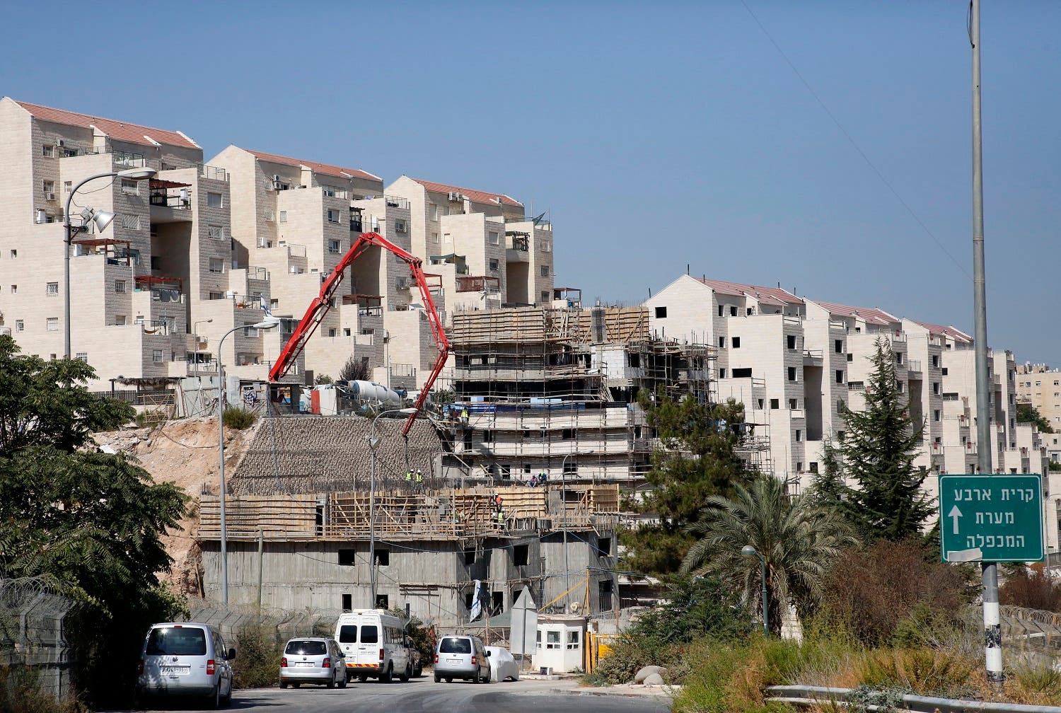 Construction workers building new houses in the Israeli settlment of Kiryat Arba, east the West Bank town of Hebron. (File photo: AFP)