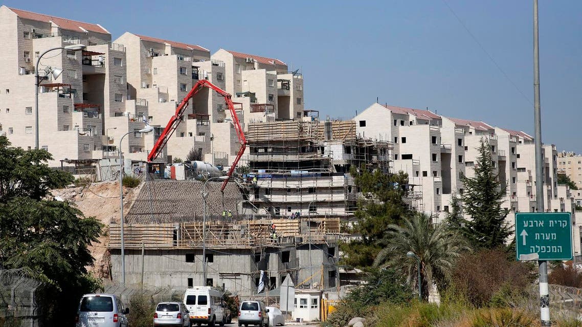 (FILES) This file photo taken on August 24, 2017 shows construction workers building new houses in the Israeli settlment of Kiryat Arba, east the West Bank town of Hebron. Israeli authorities on October 16, 2017 approved permits for 31 settler homes in Hebron in the occupied West Bank, the first such approvals for the flashpoint city since 2002, the Peace Now NGO said. (AFP)