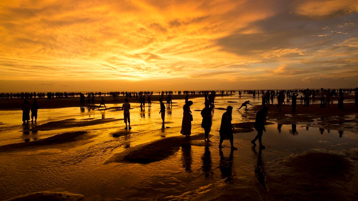 In this Sept. 22, 2017 photo, Bangladeshis walk on the beach at sunset in Cox’s Bazar, Bangladesh. (AP)