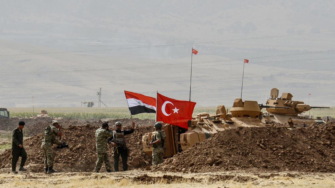 A photographer takes pictures as soldiers stand next to tanks bearing Turkish and Iraqi flags during a joint military exercise near the Turkish-Iraqi border at Silopi district in Sirnak on September 26, 2017. AFP
