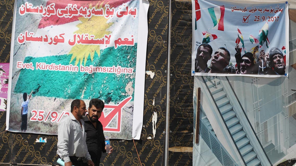 Iraqis drive past posters encouraging people to vote in the upcoming independence referendum for the Kurdistan region on September 24, 2017, in central Kirkuk. AFP)