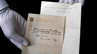 A picture taken on October 19, 2017, shows Gal Wiener, owner and manager of the Winner's auction house in Jerusalem, displays two notes written by Albert Einstein, in 1922, on hotel stationary from the Imperial Hotel in Tokyo Japan. A note that Albert Einstein gave to a courier in Tokyo, briefly describing his theory on happy living, has surfaced after 95 years and is up for auction in Jerusalem. (AFP)