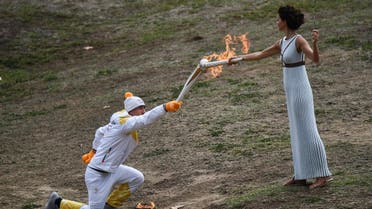 First Greek torchbearer for Pyeongchang 2018, cross-country skier Apostolos Angelis (L) lights the OLympic torch to take the first relay from the Olympic flame held by actress Katerina Lechou at the Temple of Hera on October 24, 2017 during the lighting ceremony of the Olympic flame for the 2018 Winter Olympics in Pyeongchang, South Korea. The 2018 Winter Olympics will take place from February 9 until February 25, 2017. (AFP)