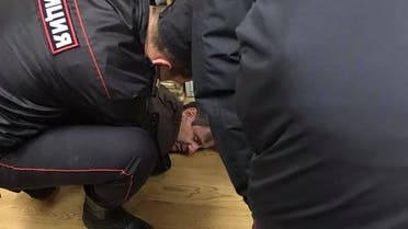 This picture obtained on Vitaly Ruvinsky's Facebook page on October 23, 2017 shows police officers detaining the man who stabbed Tatiana Felgengauer, a presenter of Echo of Moscow radio station, in Moscow. (afp)