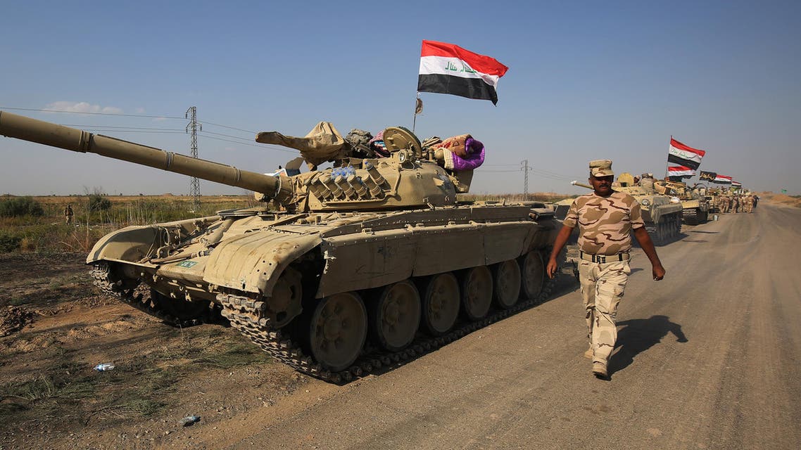 A member of the Iraqi forces walks past a tank as an army convoy drives towards Kurdish peshmerga positions on October 15, 2017, on the southern outskirts of Kirkuk. afp