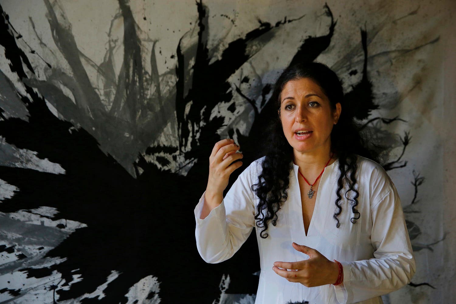 Lebanese artist Zena El Khalil speaks during an interview with The Associated Press, in front of one of her paintings in Beit Beirut, in Beirut, Lebanon. (AP)