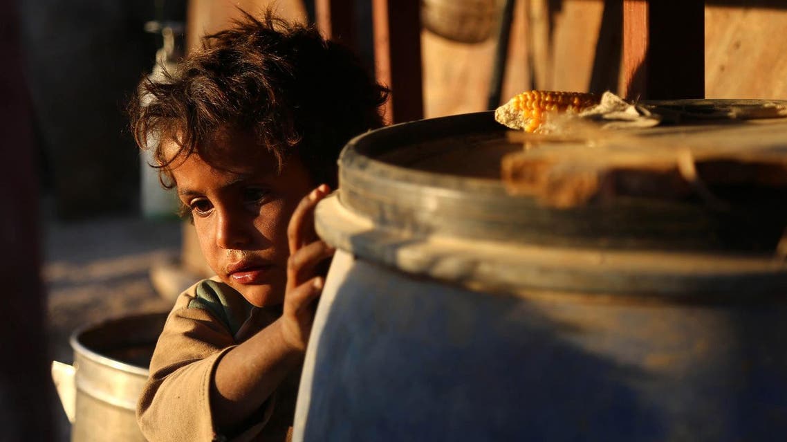 A Syrian child stands behind a barrel at the Ash'ari camp for the displaced in the rebel-held eastern Ghouta area outside the capital Damascus on October 25, 2017. (AFP)