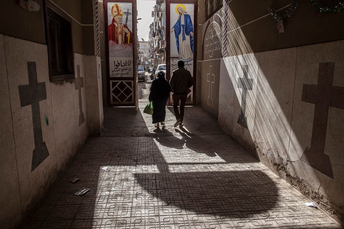 Coptic Christians walk outside St. Markos Church in Minya, south of Cairo, Egypt, where two policemen guarding the church were shot dead by unknown gunmen on the early hours of Tuesday, Jan. 6,. 2015, a day before Egypt's Coptic Christmas falls. (AP)