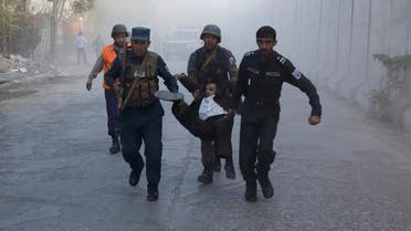Afghan policemen carry an injuried after a blast in Kabul, Afghanistan. (Reuters)