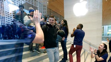 Chase Thilleman receives a high five from an Apple employee as he is first in line to buy the Apple iPhone X at the new Apple Michigan Avenue store along the Chicago River Friday, Nov. 3, 2017.
