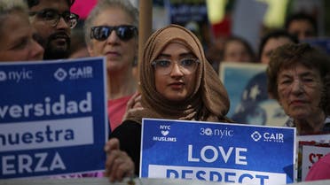 A woman holds up a poster during a rally to support Muslim rights outside City hall on June 10, 2017, in New York. (AFP)