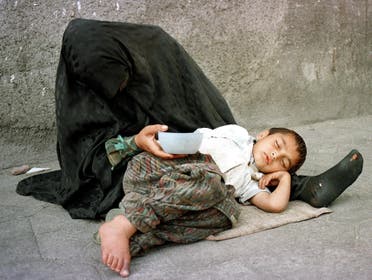 A homeless woman and her child beg for money 22 May 1999 in Tehran. (AFP)
