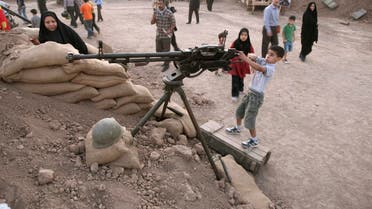 An Iranian boy plays with a weapon at a war exhibition in Tehran on September 26, 2011. (Reuters) 