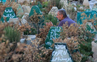 A Syrian man prays on July 12, 2017 at a cemetery in Khan Sheikhun. (AFP)