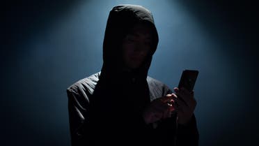 Hacker holding phone - Stock image... 