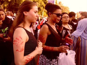 Women, with red paint on their bodies to symbolize blood, protest against sexual harassment in front of the opera house in Cairo June 14, 2014. (Reuters)