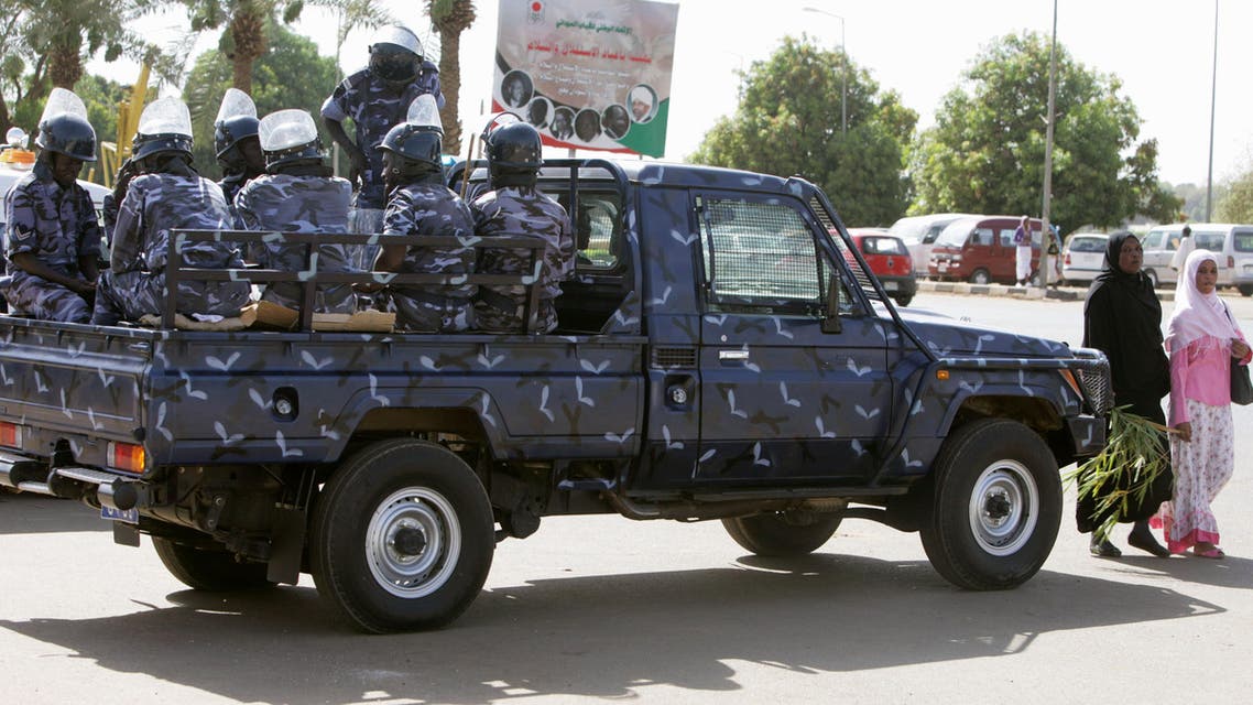 Two Sudanese women cross the street in front of a police patrol under an electoral poster with a picture of Sudanese President Omar al-Bashir in Khartoum, Sudan, Monday, April 26, 2010. ap