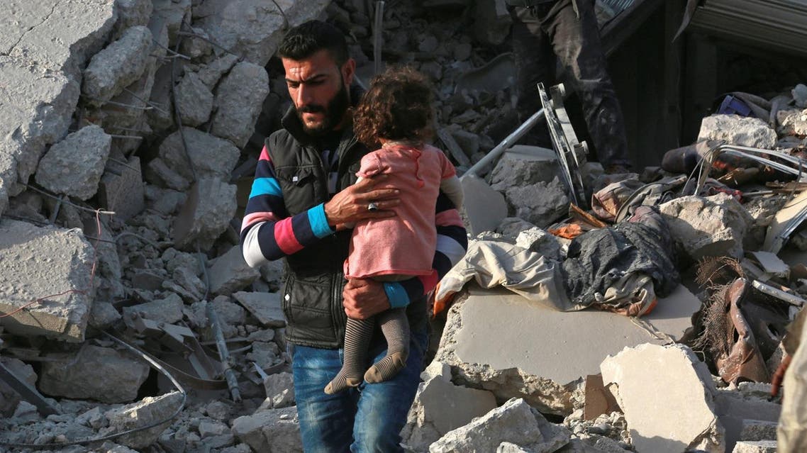 A Syrian man carries a child following a reported airstrike on the rebel-held town of Atareb in Syria's northern Aleppo province on November 13, 2017. At least 21 civilians, including five children, were killed on Monday in air strikes on Syria's northern Aleppo province, despite a "de-escalation zone" in place there, the Britain-based Syrian Observatory for Human Rights said . (AFP)