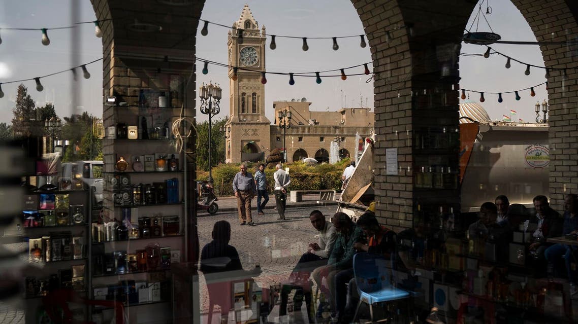 People are reflected in the window of a closed shop in central Irbil, Iraq, Wednesday, Oct. 25, 2017. (AP)