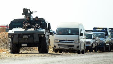 Egyptian security forces' vehicles and armored personnel carriers (APCs) parked on the desert road near the site of an attack that left at least a dozen policemen killed in an ambush by militant fighters. (AFP)