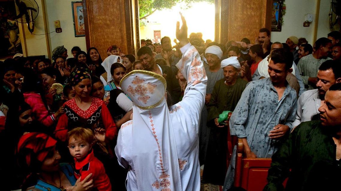 A Coptic Christian priest blesses his congregation with holy water during Sunday service in the Virgin Mary Church at Samalout Diocese in Al-Our village, in Minya governorate, south of Cairo. (Reuters)