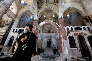 Bishop-General Macarius, a Coptic Orthodox leader, walks around the burnt and damaged Evangelical Church in Minya governorate, about 245 km (152 miles) south of Cairo, August 26, 2013. (Reuters)