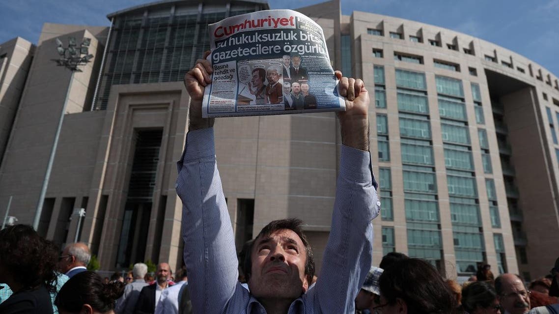 A press freedom activist holds a copy of the opposition newspaper Cumhuriyet during a demonstration in solidarity with the jailed members of the opposition newspaper Cumhuriyet outside a courthouse, in Istanbul. (Reuters)