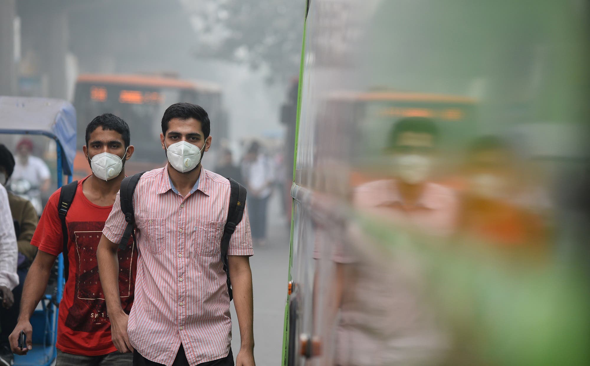 Indian commuters wear masks as they walk along a road amid heavy smog in New Delhi on November 9, 2017. (AFP)