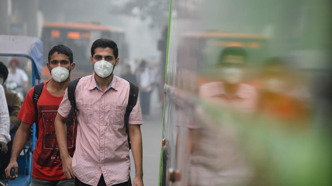 Indian commuters wear masks as they walk along a road amid heavy smog in New Delhi on November 9, 2017. (AFP)