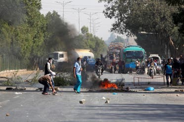 Supporters of the Tehreek-e-Labaik Pakistan place hurdles and block the main road leading to airport in Karachi. (Reuters)