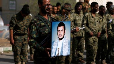 Newly recruited fighter holds a poster of the Houthi movement's leader Abdulmalik al-Houthi. (Reuters)