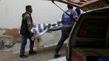 Rescue workers move one of two bodies of a couple, who according to police was killed by family members, outside hospital morgue in Karachi. (Reuters)