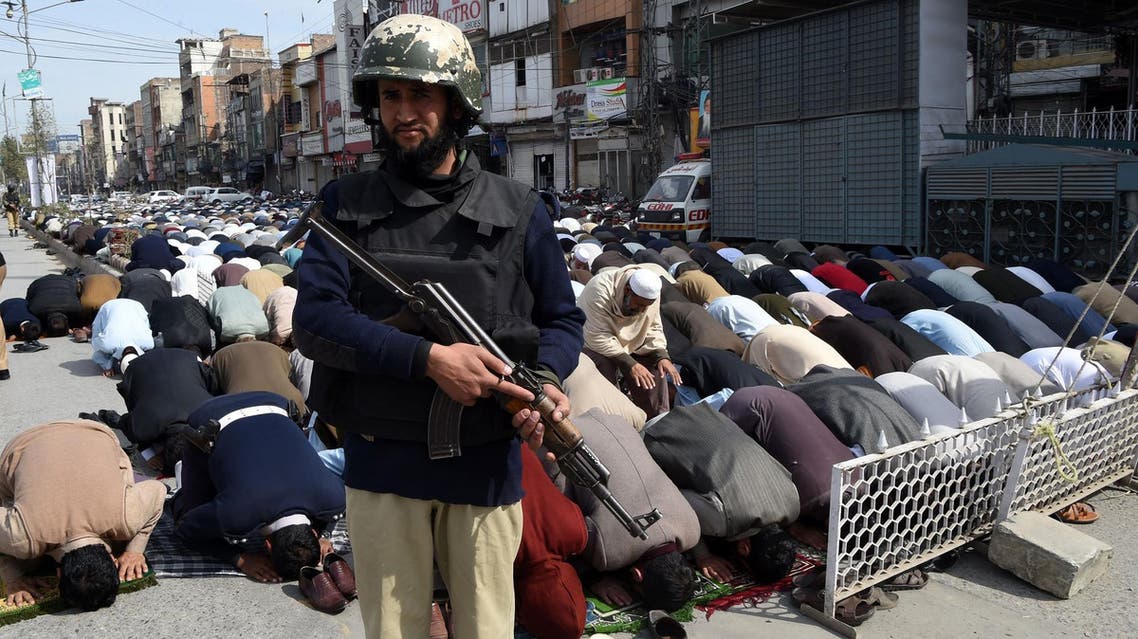 A Pakistani policeman stands guard as Muslims offer Friday prayers on a street in Peshawar on February 17, 2017. (AFP)